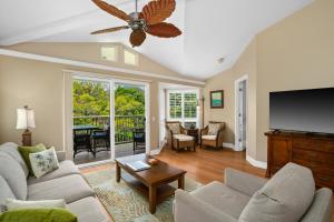 un salon avec un canapé et une télévision à écran plat dans l'établissement VOK29 Hawaiiana 3br 3ba Villa of Kamalii, AC, Pool, à Princeville