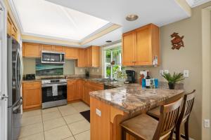 une grande cuisine avec des armoires en bois et un comptoir dans l'établissement VOK29 Hawaiiana 3br 3ba Villa of Kamalii, AC, Pool, à Princeville