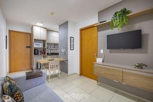 a living room with a couch and a tv on a wall at Condomínio c/ Academia e Piscina TCR in Riacho Fundo