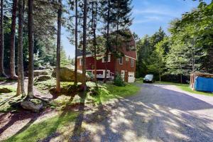 a house in the woods with a car parked in the driveway at Southport Island Cottage in Hendricks Harbor