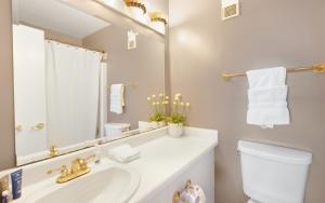 a bathroom with a sink and a toilet and a mirror at Ocean Breezes by Oversee 30A in Carillon Beach