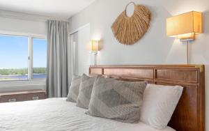 a bedroom with a bed with pillows and a window at Ocean Breezes by Oversee 30A in Carillon Beach