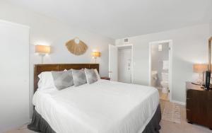 a bedroom with a white bed and a bathroom at Ocean Breezes by Oversee 30A in Carillon Beach