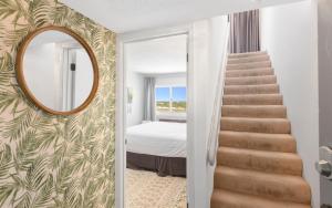 a stairway leading to a bedroom with a mirror at Ocean Breezes by Oversee 30A in Carillon Beach +17 photos