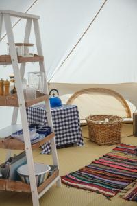 a room with a ladder and baskets and a rug at Glamping Meadow Bell Tent in Stithians