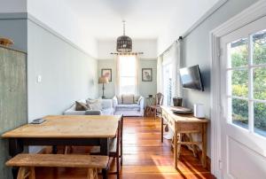 a living room with a table and a couch at Villa Florence in Martinborough