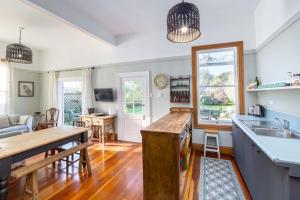 an open kitchen and living room with a wooden table at Villa Florence in Martinborough