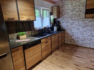 a kitchen with wooden cabinets and a sink at Domek Chańcza in Chańcza +13 photos