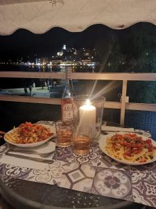 a table with two plates of food and a bottle of wine at magda's house in Galatas