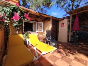 a yellow chair and a couch on a patio at La Casita de Claudia in Aguatona