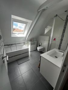 a white bathroom with a tub and a sink at Maison vue Rivière du Bono 8 personnes in Le Bono