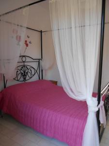 1 dormitorio con cama rosa y dosel en ANAMAMA -SOCRATES studios, en Acharavi