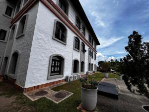 Un edificio blanco con plantas delante. en RUITOQUE CONDOMINIO Apartamento, en Piedecuesta