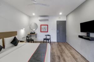 a bedroom with a large bed and a flat screen tv at Super Townhouse RCC Majestic 397 LB Nagar in Hyderabad