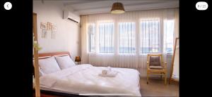 Un dormitorio con una cama y una silla y ventanas. en Sound, en Konak