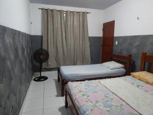 a bedroom with two twin beds and a fan at Casa para temporada in Belém