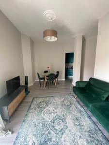 a living room with a green couch and a table at Appartamento SOLARIUM in Rapallo