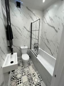 a bathroom with a toilet and a tub and a sink at Central Two-three bedroom Beach town maisonette in Southsea +3 photos