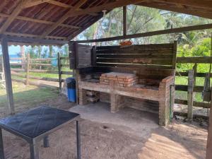 a barbecue grill with a table and a fence at Villa Playa Encantada in Barra de Tuxpan
