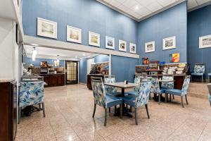 a restaurant with blue walls and tables and chairs at Best Western Riverside Inn in Macon