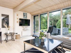 un salon avec une table et une télévision dans l'établissement 8 person holiday home in Oksbøl-By Traum, à Oksbøl