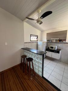 a kitchen with a counter and two stools in it at Flat Maricá com ar-condicionado in Maricá