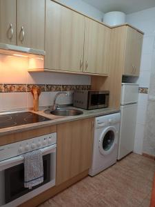 a kitchen with a sink and a washing machine at Expoholidays - Estudio a pie de playa in Almerimar
