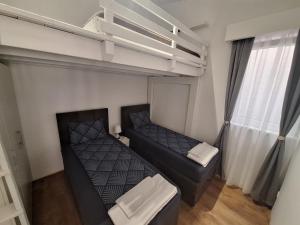 a small bedroom with two beds and a loft at Matino Apartments 3 in Valjevo