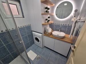 a bathroom with a sink and a washing machine at Matino Apartments 3 in Valjevo +36 photos