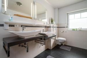 a bathroom with two sinks and a toilet at Ferienhaus-Spiekeroog-an-der-Mueritz in Zielow