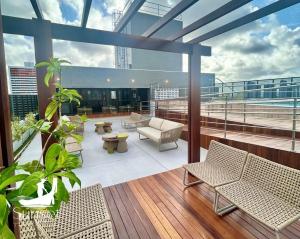 a balcony with chairs and a couch on a building at Studio Sunset João Pessoa in João Pessoa