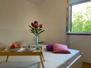 a bedroom with a table with a vase of flowers on a bed at Holiday house with a swimming pool Grubine, Zagora - 22263 in Krivodol