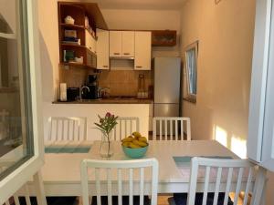 a kitchen with a table with a bowl of fruit on it at Holiday house with a swimming pool Grubine, Zagora - 22263 in Krivodol +4 photos