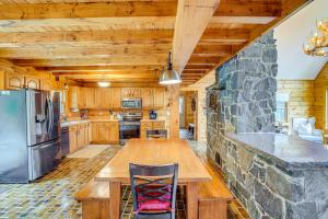 a kitchen with a table and a refrigerator at Spacious Wilmington Cabin Walk to Lake in Wilmington