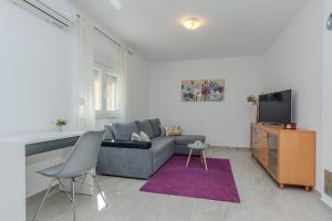 a living room with a couch and a tv at Family friendly house with a swimming pool Privlaka, Zadar - 23516 in Privlaka