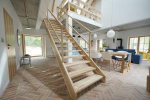a wooden staircase in a living room with a table at Sąsny in Łajs