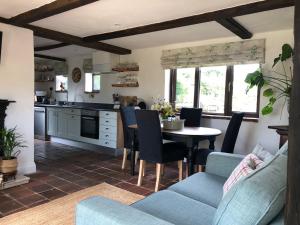 a kitchen and living room with a table and chairs at The Old Workhouse Paddocks in Bawdeswell
