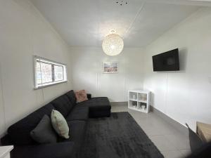 a living room with a black couch and a tv at Mandurah Coastal Holiday Park in Mandurah