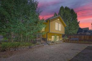 una casa amarilla con una valla delante en Imperial View Cottage Home, en Breckenridge