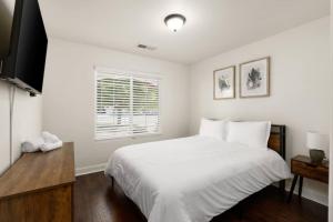 ein weißes Schlafzimmer mit einem großen Bett und einem Fenster in der Unterkunft Perfect Home for Work or Relaxing Vacation in Bakersfield