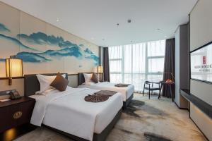um quarto de hotel com duas camas e uma TV de tela plana em 丽呈東谷酒店保定客运中心店 em Baoding