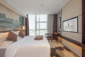 Uma cama ou camas num quarto em 丽呈東谷酒店保定客运中心店