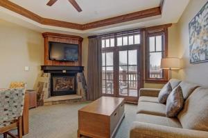 a living room with a couch and a fireplace at Luxury 1 Bedroom Ski In, Ski Out One Ski Hill Residence Located At The Base Of Peak 8 With Bowling Alley Onsite in Breckenridge