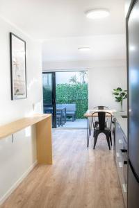 een woonkamer met een tafel en een eetkamer bij The Downtown - A Mount Maunganui Apartment in Mount Maunganui +6 foto's