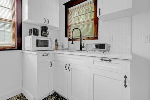 a white kitchen with a sink and a microwave at Spacious 4BR 1BA near the Falls in Niagara Falls