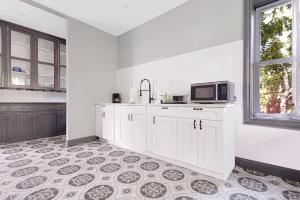 a kitchen with white cabinets and a microwave at Cozy 4BR 1BA close to the Falls in Niagara Falls +16 photos