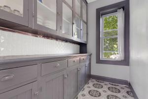 a kitchen with white cabinets and a window at Cozy 4BR 1BA close to the Falls in Niagara Falls