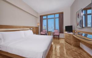 um quarto de hotel com uma cama e uma televisão em Nina Hotel Causeway Bay em Hong Kong