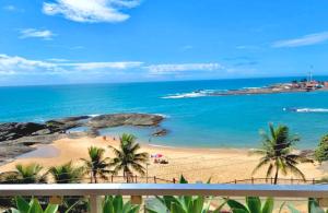 a view of a beach with palm trees and the ocean at Hotel Atlântico in Guarapari