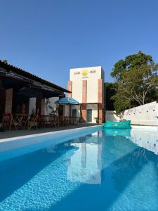 a swimming pool in front of a building at Santa Areia Lençóis Pousada in Santo Amaro